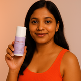 Woman holding a skincare product with a plain background